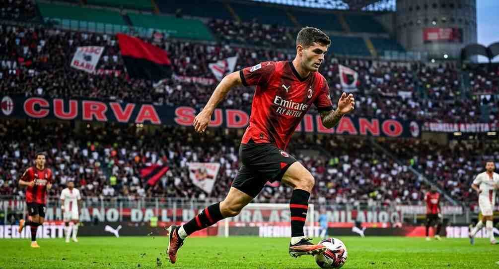 A high-quality 4K action shot of Christian Pulisic dribbling the ball in the 2026 AC Milan kit during a match against SSC Bari.